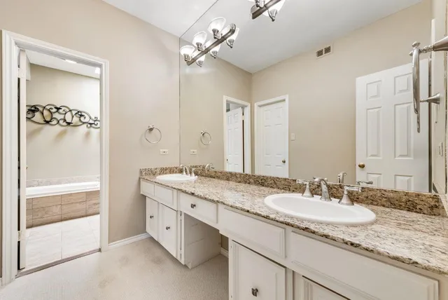 a bathroom with a granite countertop sink a light fixture and a mirror