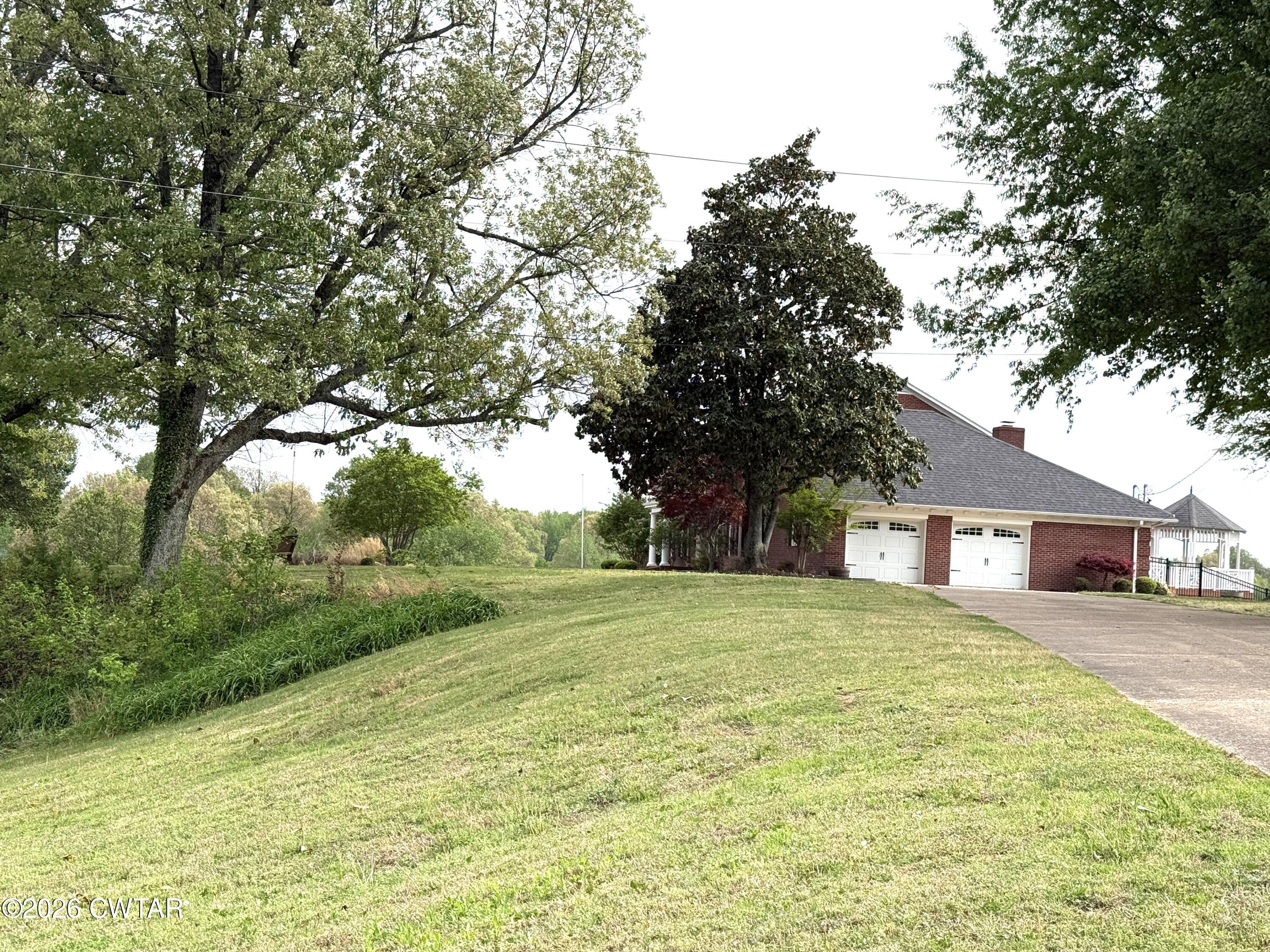 2787 Meacham Road Dyersburg, TN 38024 - Photo 17 of 45 a view of a yard with a house and large trees
