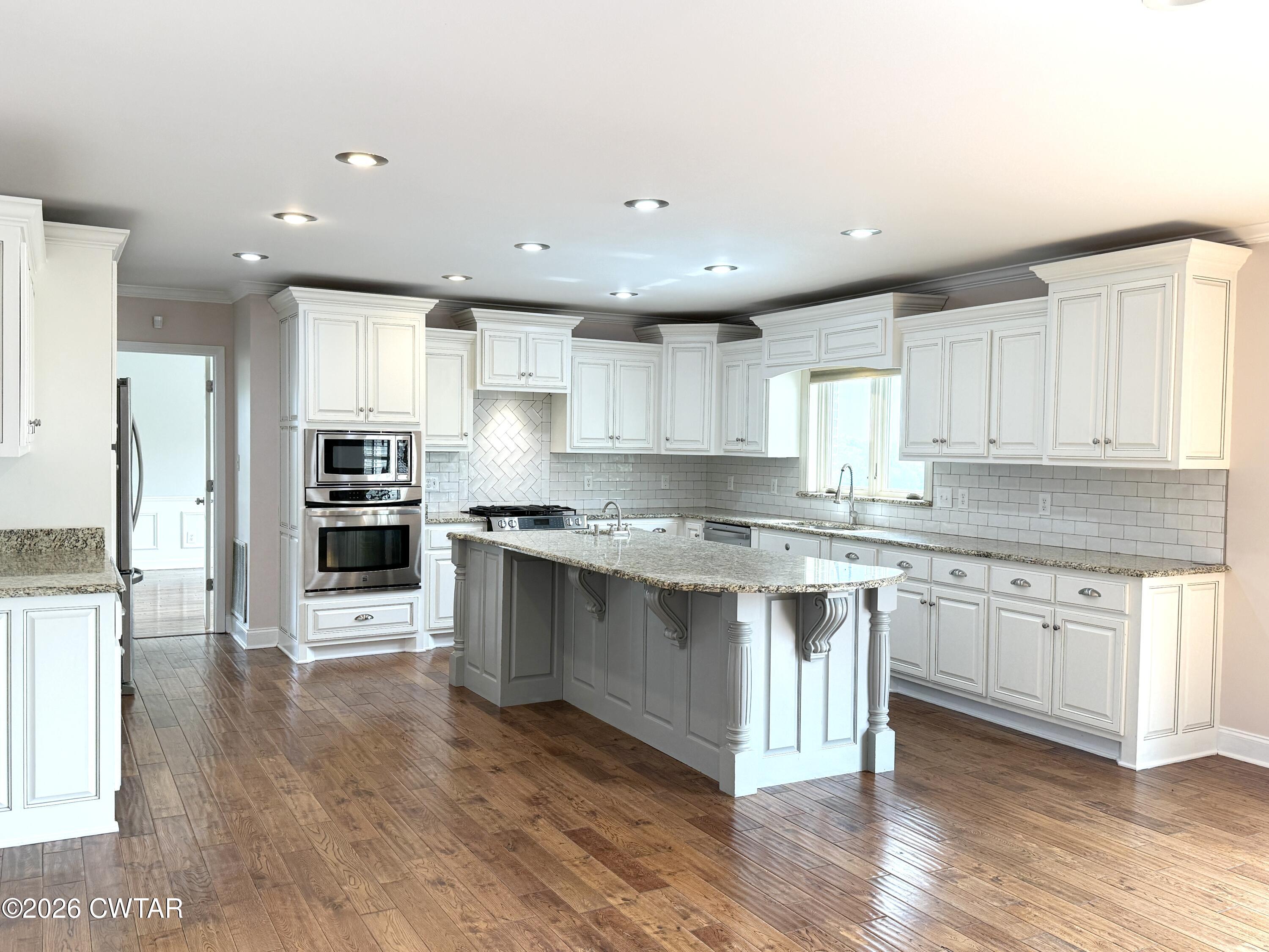 2787 Meacham Road Dyersburg, TN 38024 - Photo 20 of 45 a large kitchen with stainless steel appliances granite countertop a stove and a sink