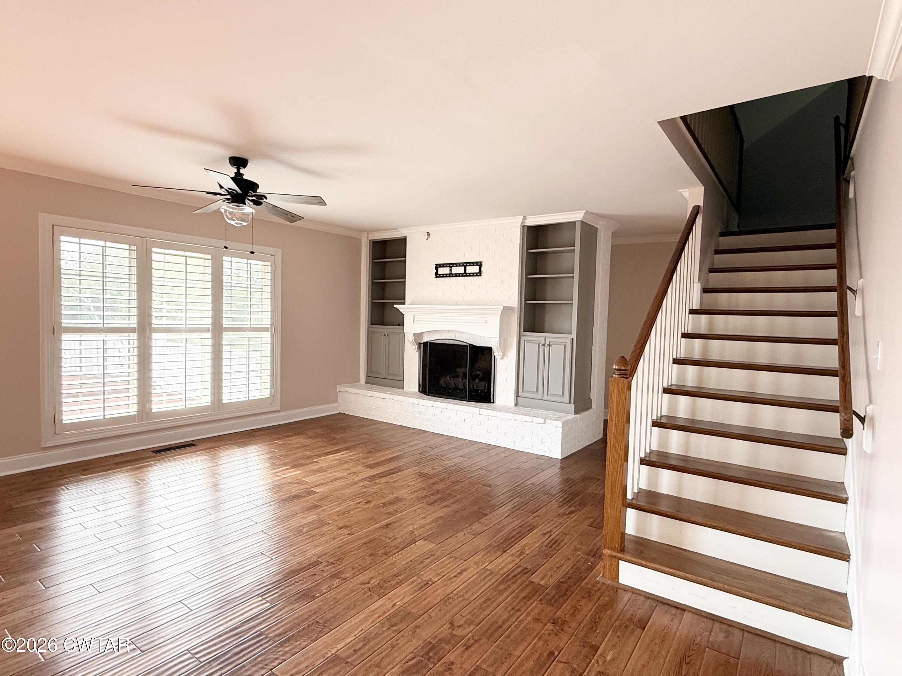 2787 Meacham Road Dyersburg, TN 38024 - Photo 24 of 45 wooden floor in an empty room with a fireplace and wooden floor