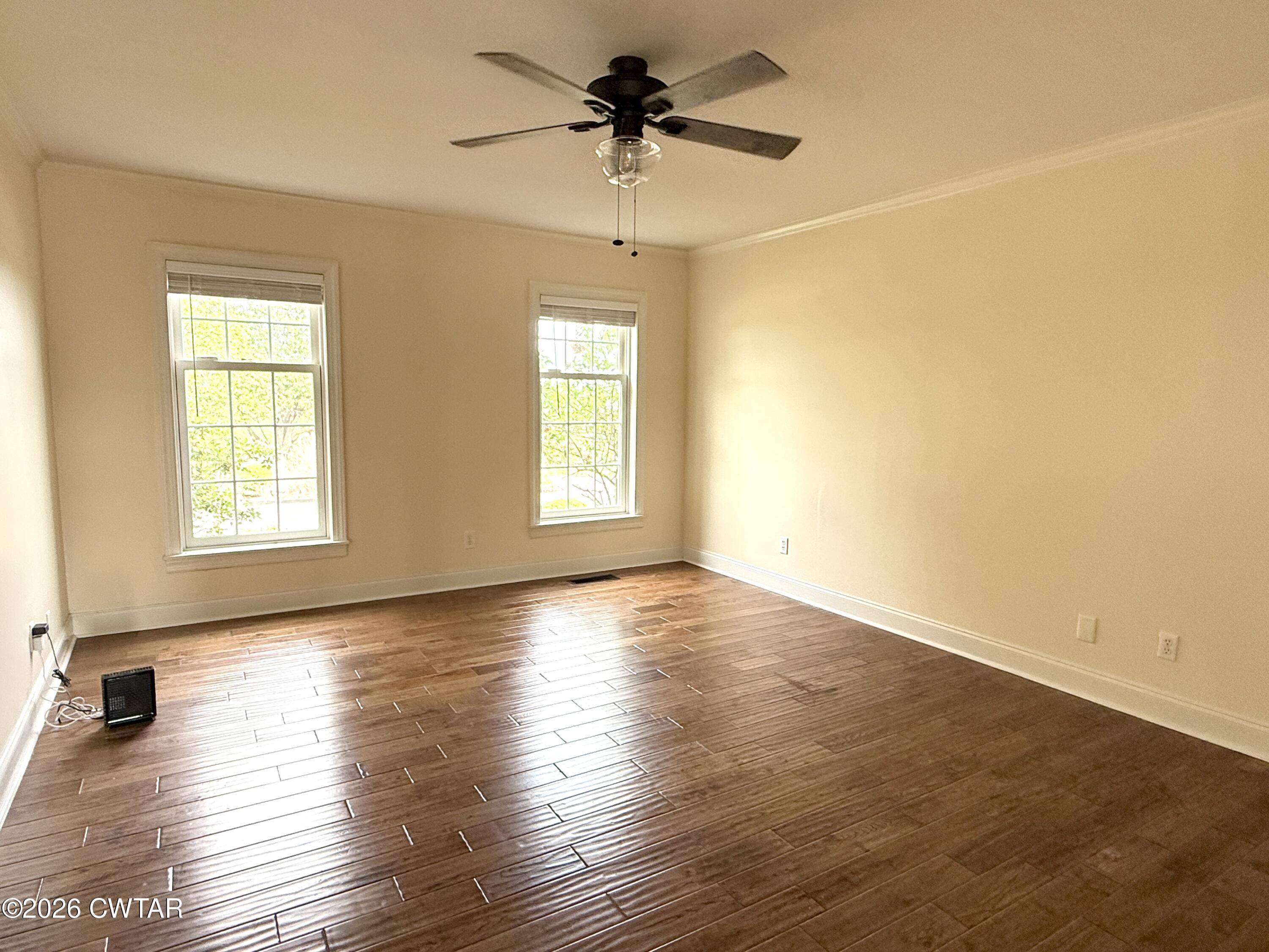 2787 Meacham Road Dyersburg, TN 38024 - Photo 26 of 45 an empty room with wooden floor chandelier fan and windows