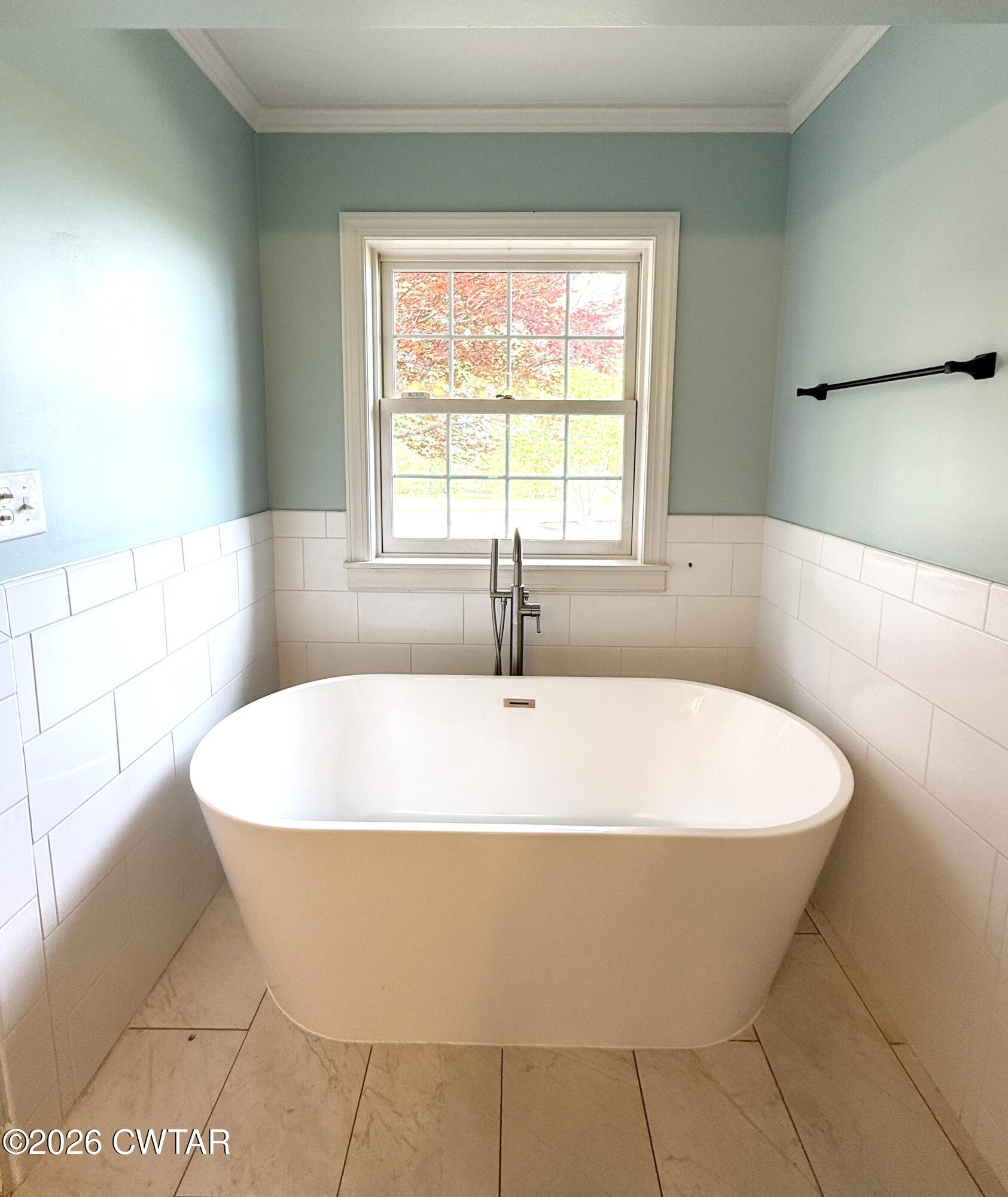 2787 Meacham Road Dyersburg, TN 38024 - Photo 28 of 45 a white bath tub sitting in a bathroom next to a window