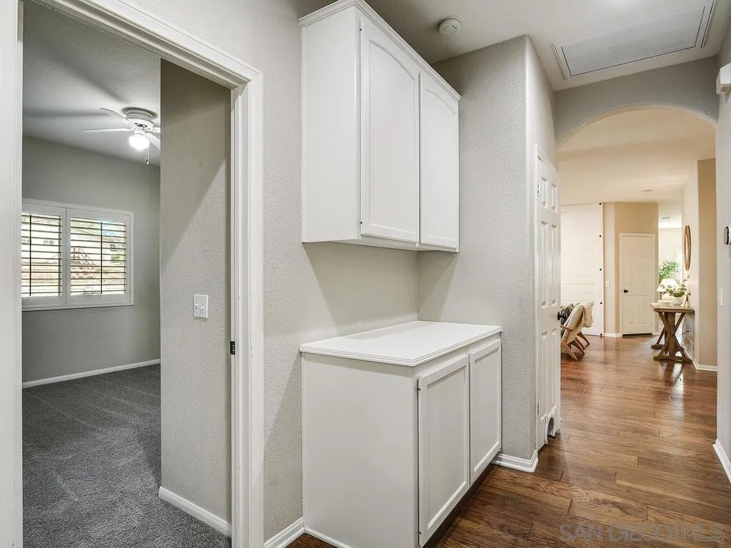 16304 Dartolo Road Ramona, CA 92065 - Photo 26 of 36 a view of a hallway with wooden floor and a living room