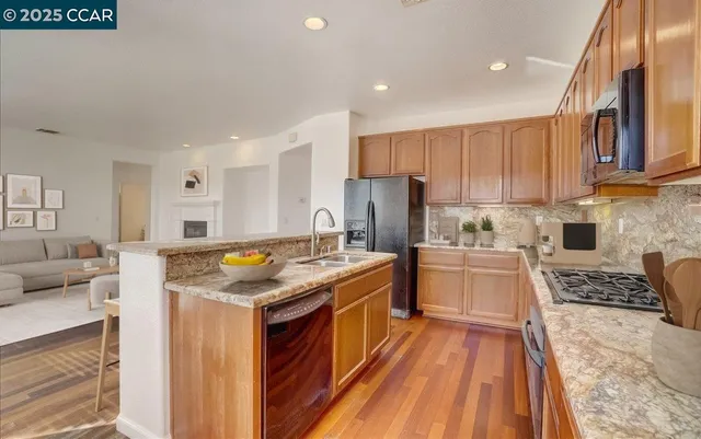 a kitchen with a stove a refrigerator and white cabinets