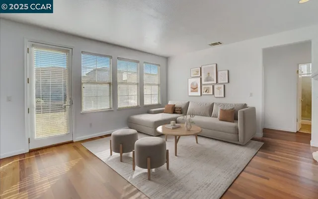 a living room with furniture and wooden floor