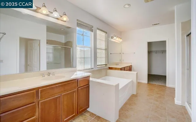 a spacious bathroom with a sink double vanity granite and a mirror