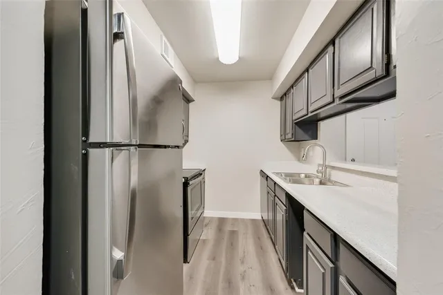 a kitchen with stainless steel appliances granite countertop a refrigerator a sink and dishwasher
