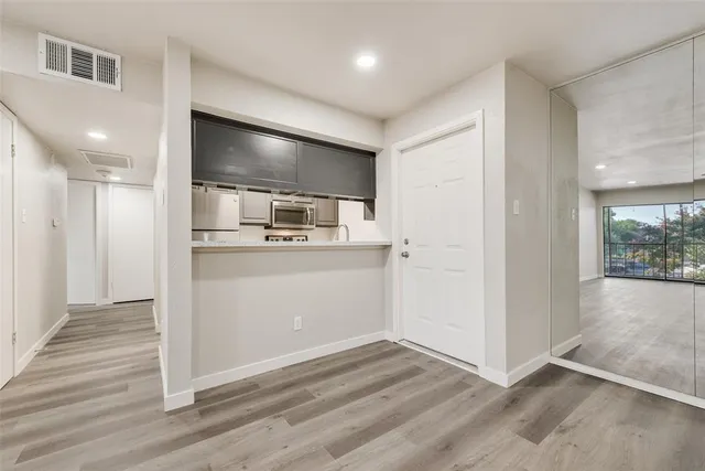 a view of a kitchen with a sink and wooden floor