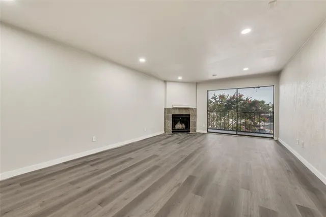 an empty room with wooden floor and a fireplace