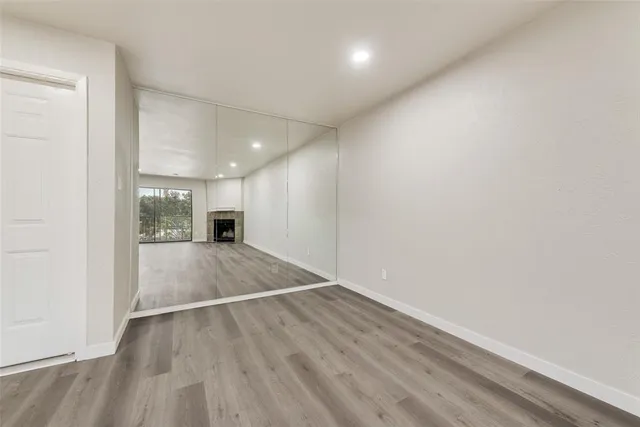a view of a room with wooden floor and a window