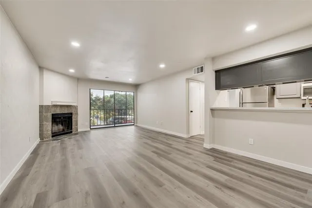 an empty room with wooden floor and fireplace