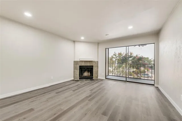 wooden floor fireplace and windows in an empty room