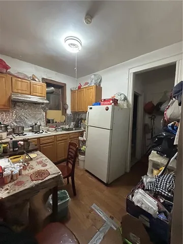 a kitchen with a refrigerator and a stove top oven