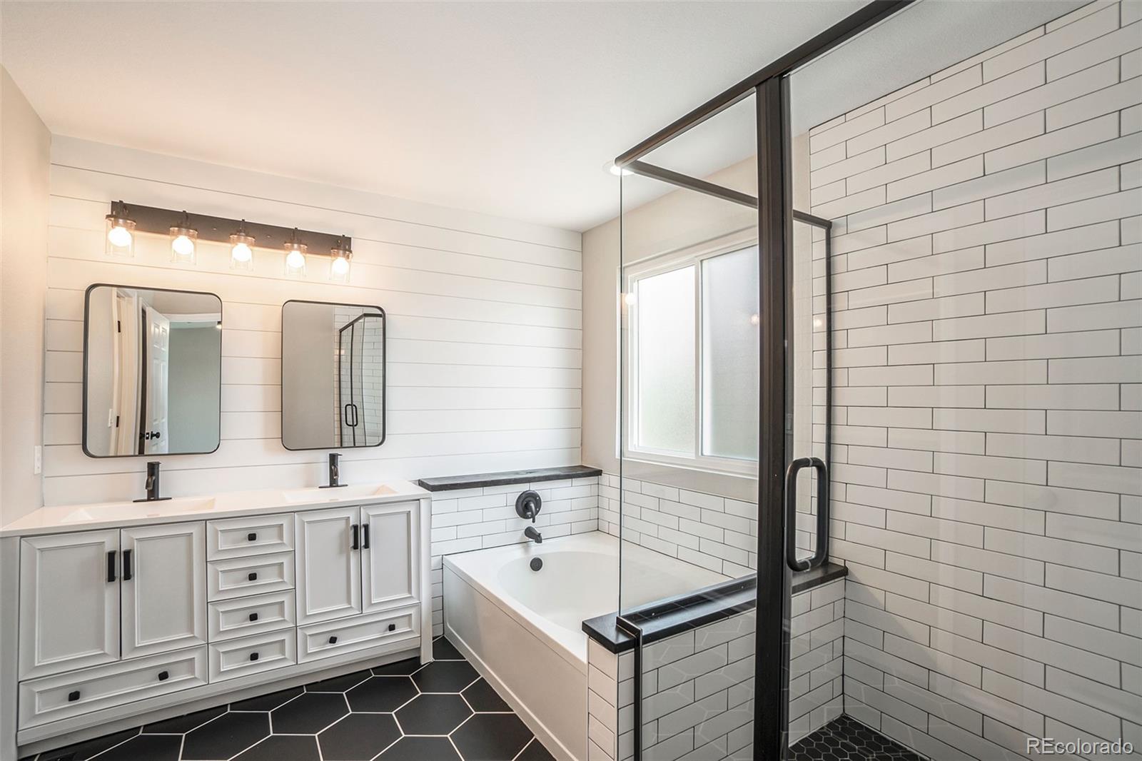 6000 South Summer Ridge Way Castle Rock, CO 80109 - Photo 6 of 19 a bathroom with a double vanity sink a mirror and a bathtub