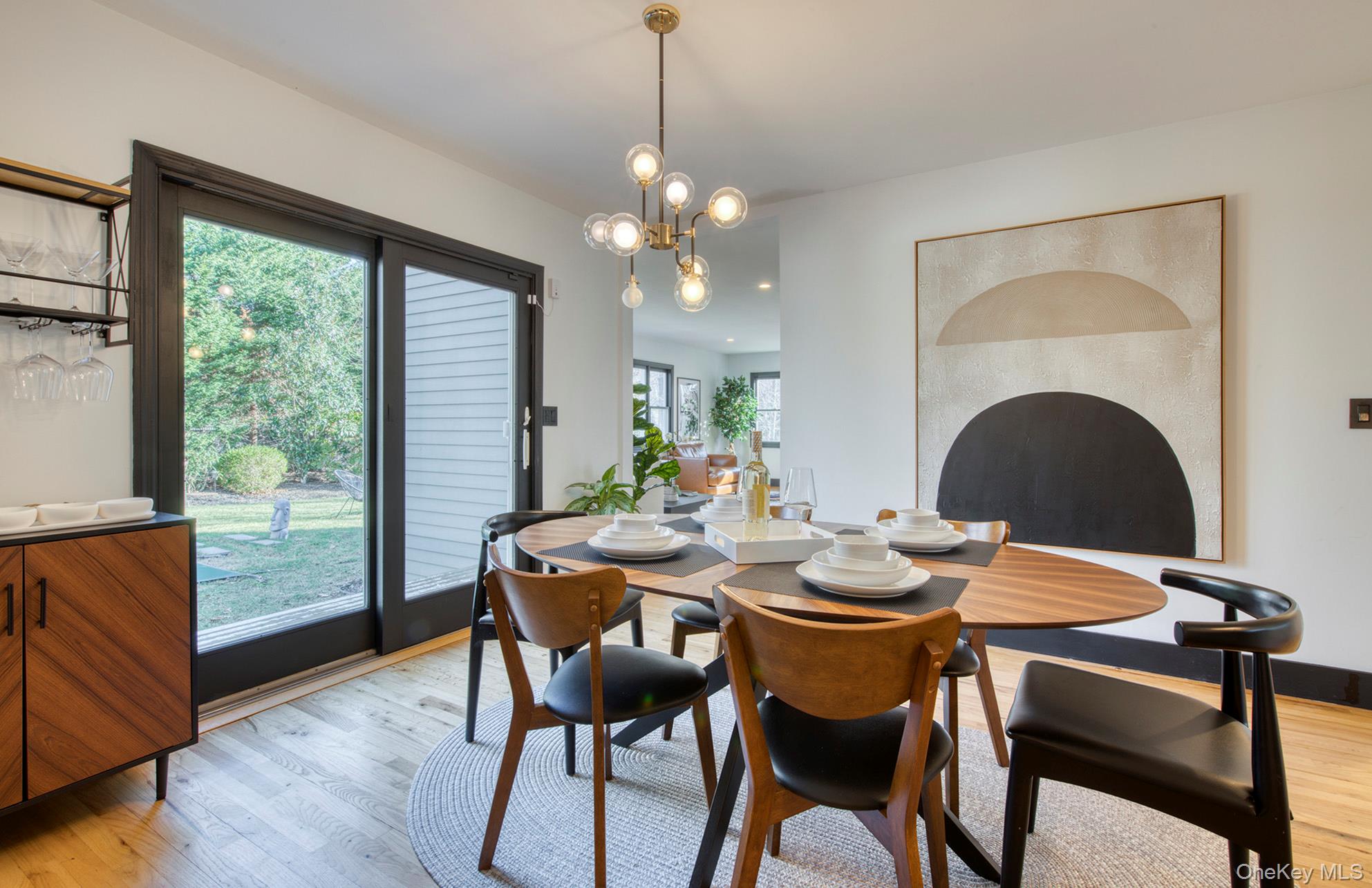 66 Knoll Road Southampton, NY 11968 - Photo 14 of 31 a dining room with furniture a floor to ceiling window and wooden floor