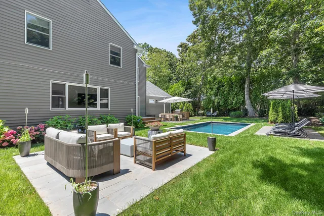 a view of a house with backyard sitting area and swimming pool