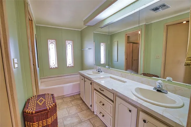a spacious bathroom with a sink double vanity granite tub shower and a mirror