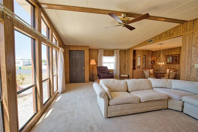 a living room with furniture and a ceiling fan