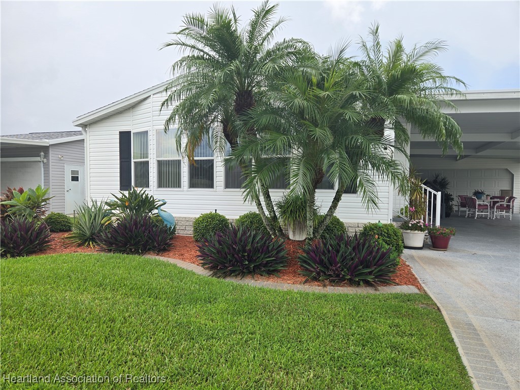 3312 Beartooth Pass Sebring, FL 33872 - Photo 30 of 39 a view of a house with a yard and potted plants