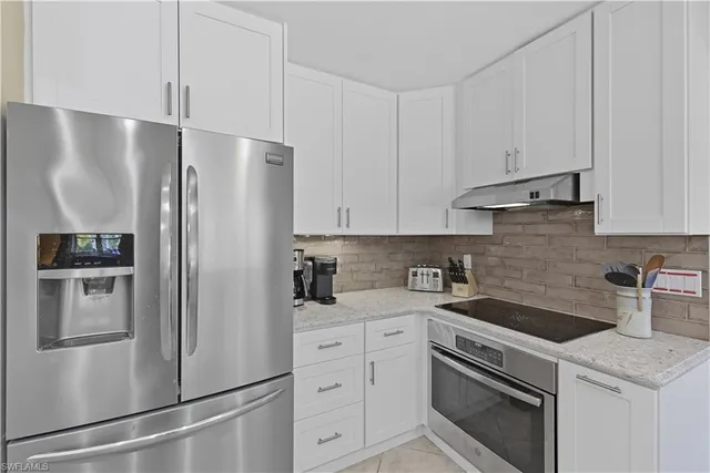 a kitchen with stainless steel appliances white cabinets and a refrigerator