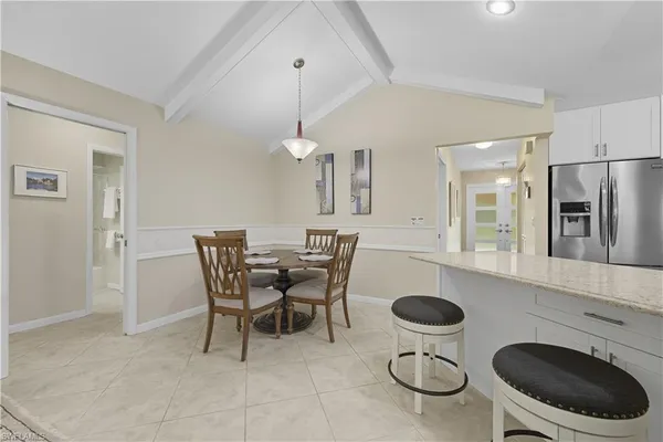 a kitchen with a dining table chairs and a refrigerator