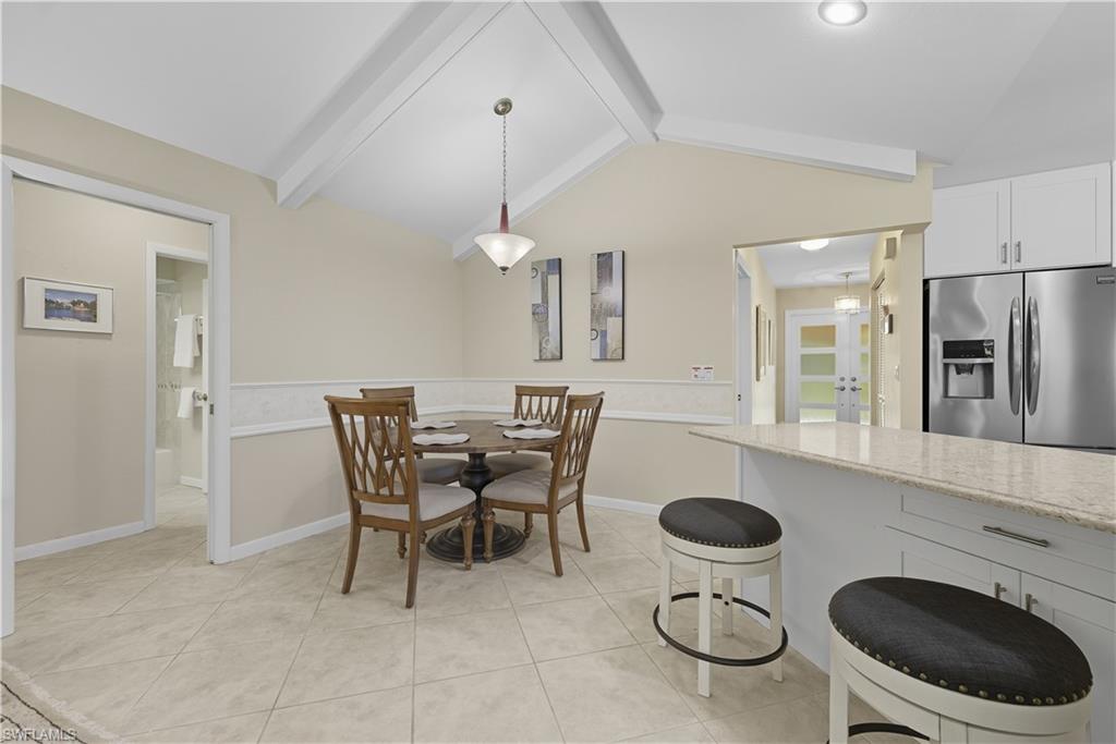 2261 Kings Lake Boulevard Naples, FL 34112 - Photo 14 of 43 a kitchen with a dining table chairs and a refrigerator
