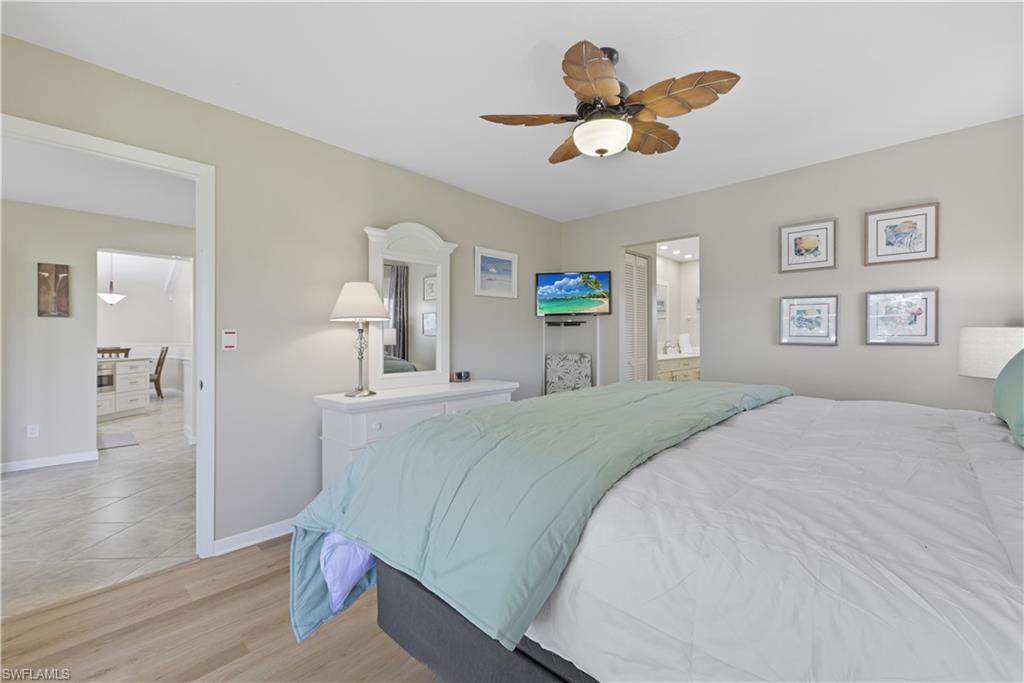 2261 Kings Lake Boulevard Naples, FL 34112 - Photo 18 of 43 a bed room with a bed and a chandelier