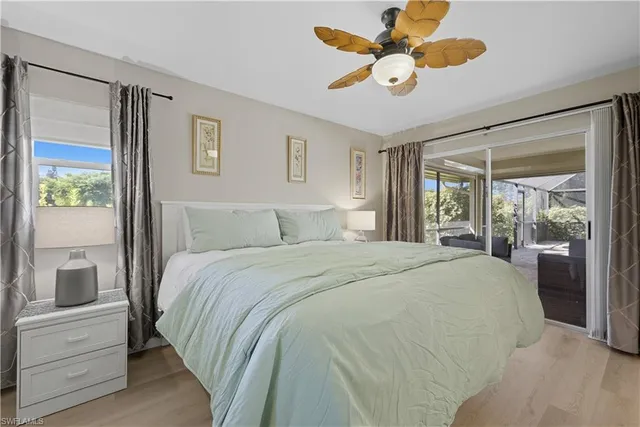 a bedroom with a large bed and a chandelier fan