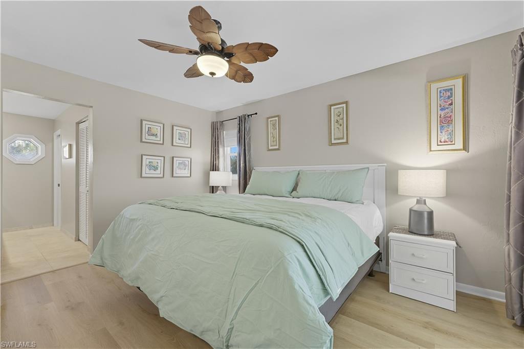 2261 Kings Lake Boulevard Naples, FL 34112 - Photo 20 of 43 a bedroom with a bed chandelier painting on the wall and a large window