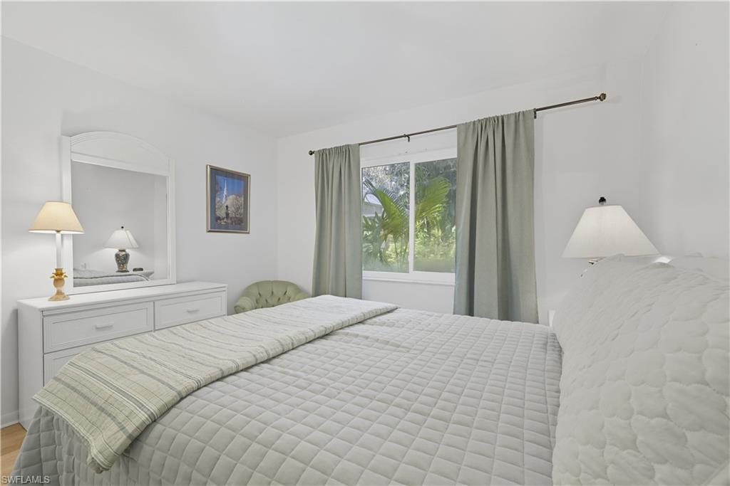 2261 Kings Lake Boulevard Naples, FL 34112 - Photo 29 of 43 a bedroom with a large bed and a window