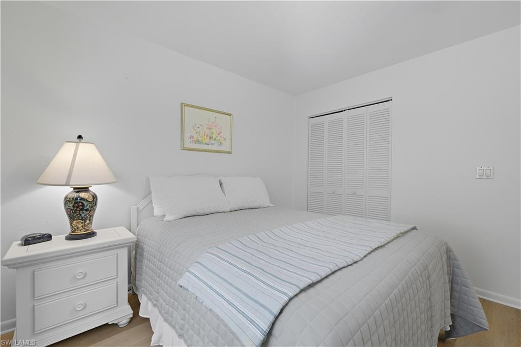 2261 Kings Lake Boulevard Naples, FL 34112 - Photo 30 of 43 a bedroom with a bed and a lamp on the dresser