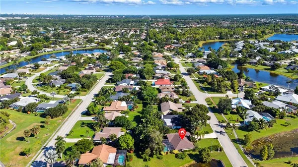 an aerial view of residential houses with outdoor space and trees