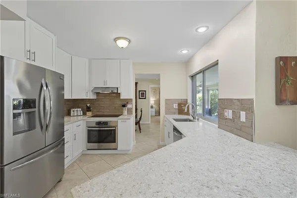 a kitchen with refrigerator a stove and cabinets