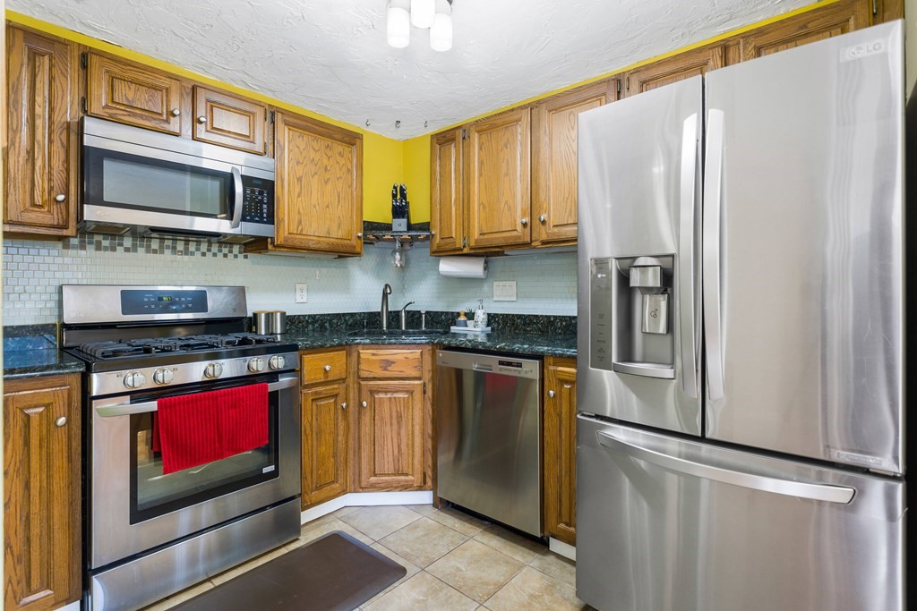 33 Trailside Way, Unit 33 Ashland, MA 01721 - Photo 4 of 26 a kitchen with stainless steel appliances granite countertop a refrigerator stove top oven and sink