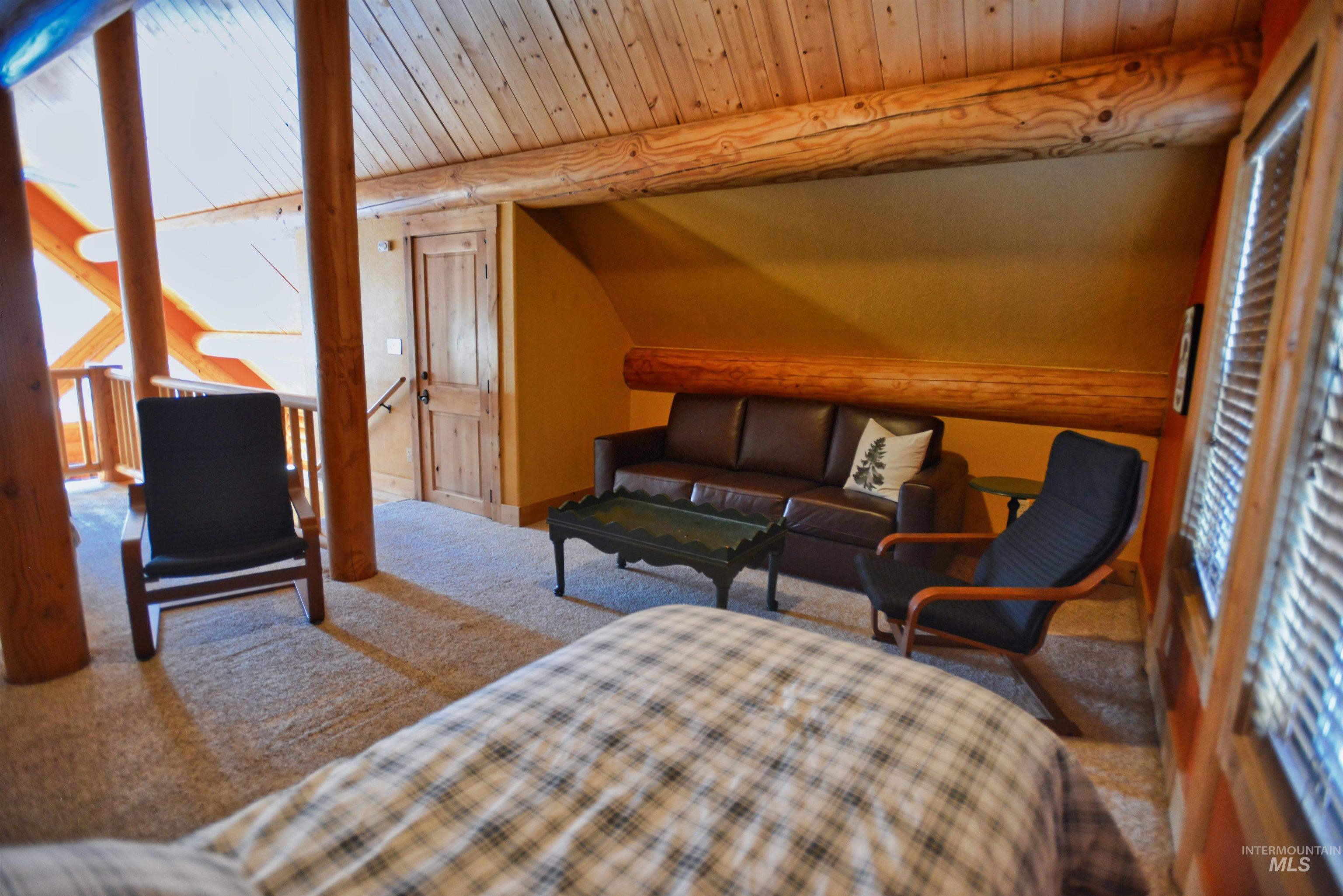 788 Chad Loop McCall, ID 83638 - Photo 10 of 22 Loft area featuring exposed wood beams, plank wood ceiling, and a light-colored carpeted floor