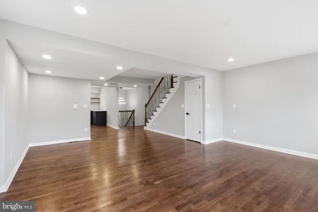 a view of an empty room with wooden floor and cabinet