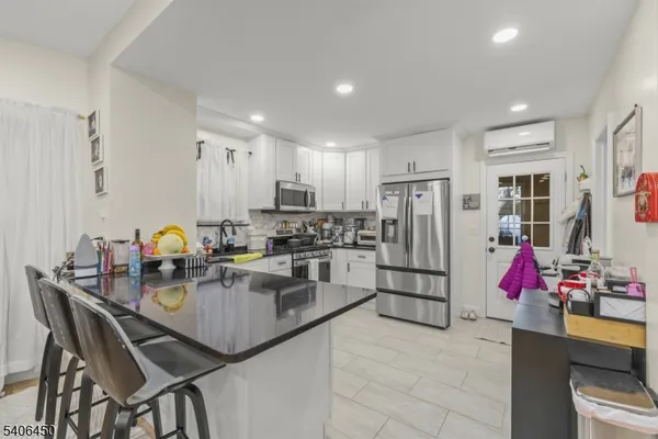 a kitchen with stainless steel appliances kitchen island granite countertop a refrigerator and microwave