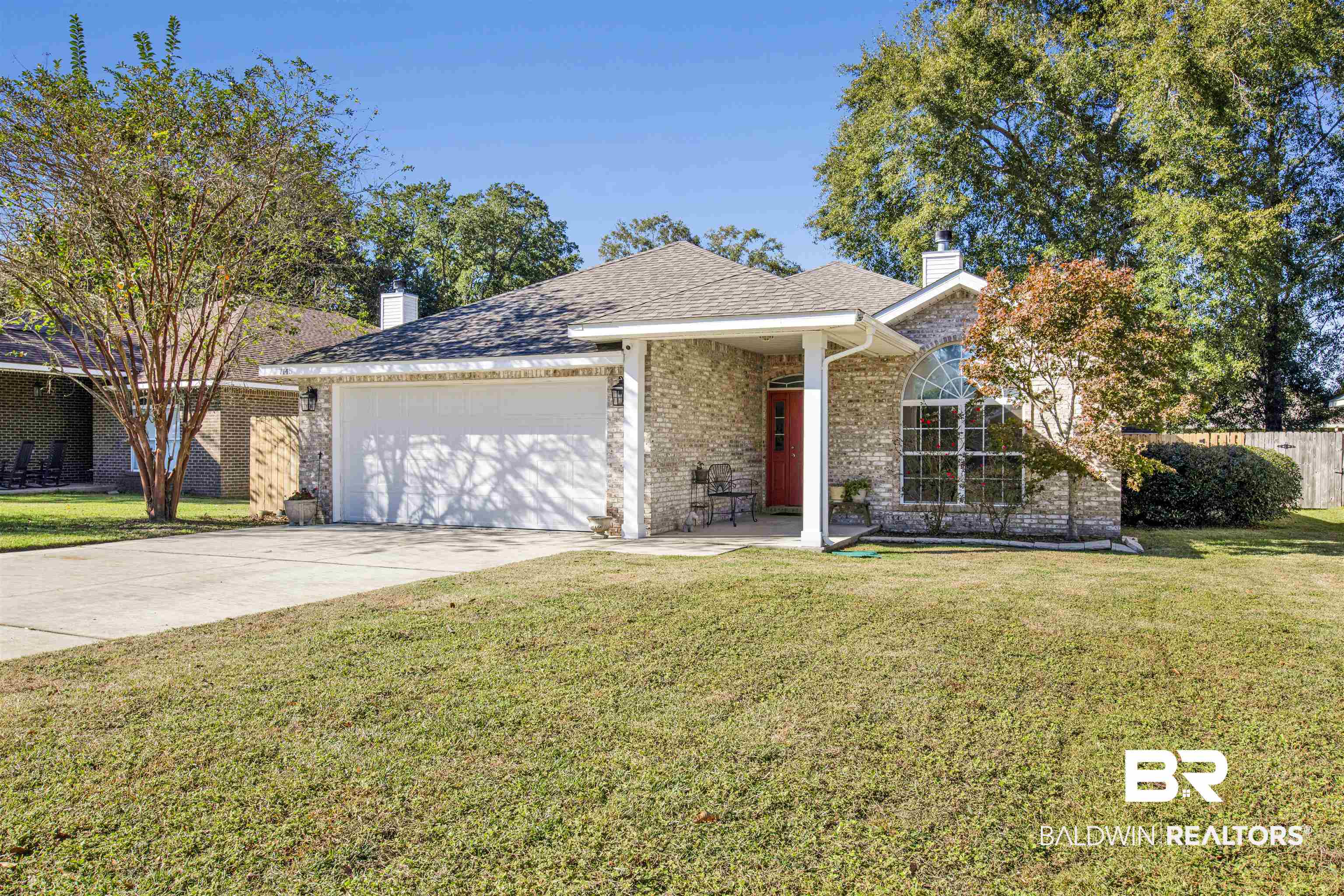 7145 Raintree Lane Gulf Shores, AL 36542 - Photo 2 of 25 View of front facade featuring a garage and a front lawn