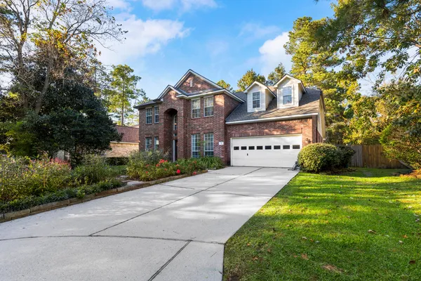 a view of a big house with a big yard and large trees
