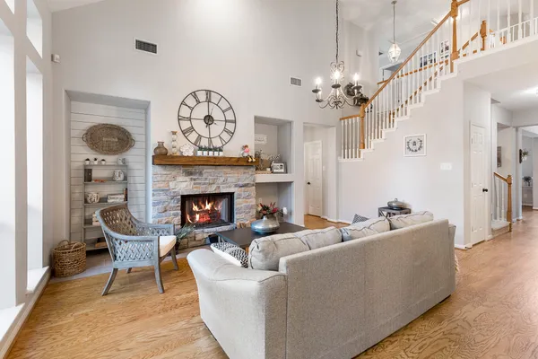 a living room with furniture a fireplace and a chandelier