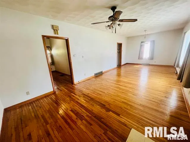 a view of empty room with wooden floor