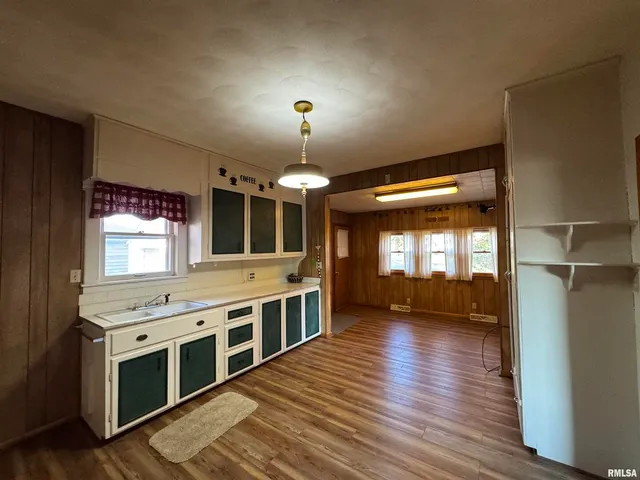 a view of a kitchen with a sink and wooden floor