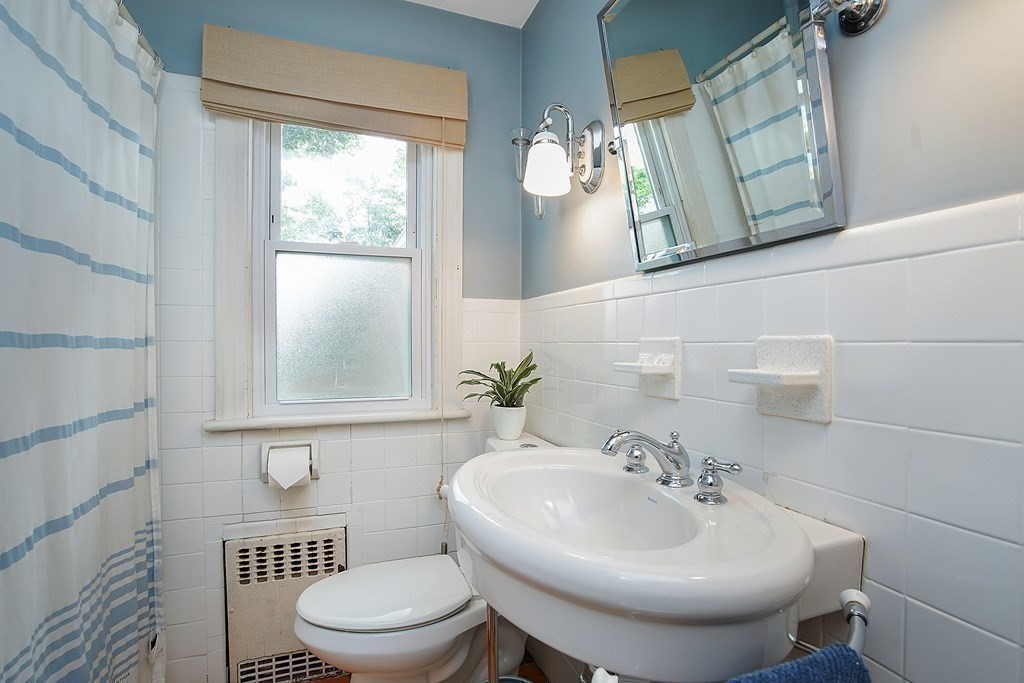 105 Lancaster Street Springfield, MA 01118 - Photo 17 of 38 a bathroom with a toilet a sink and a mirror