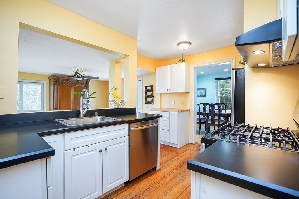 105 Lancaster Street Springfield, MA 01118 - Photo 3 of 38 a kitchen with stainless steel appliances granite countertop a sink a stove and a wooden floors
