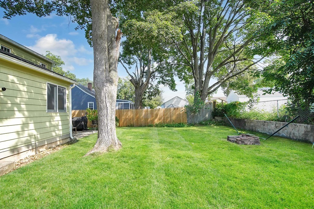 105 Lancaster Street Springfield, MA 01118 - Photo 34 of 38 a view of a backyard with a bench under a large tree