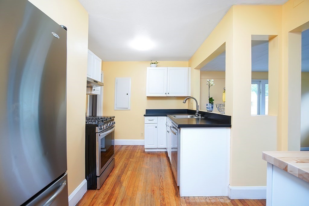 105 Lancaster Street Springfield, MA 01118 - Photo 5 of 38 a kitchen with a sink a refrigerator and wooden floor