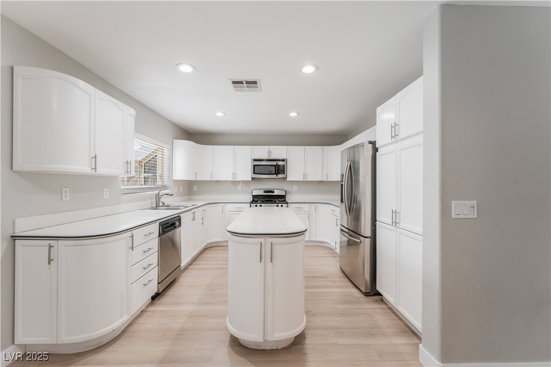 3695 Funston Way Las Vegas, NV 89129 - Photo 6 of 43 Kitchen with a center island, stainless steel appliances, light countertops, white cabinetry, and recessed lighting