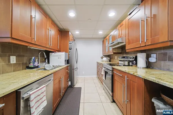 a kitchen with stainless steel appliances granite countertop a stove sink and cabinets