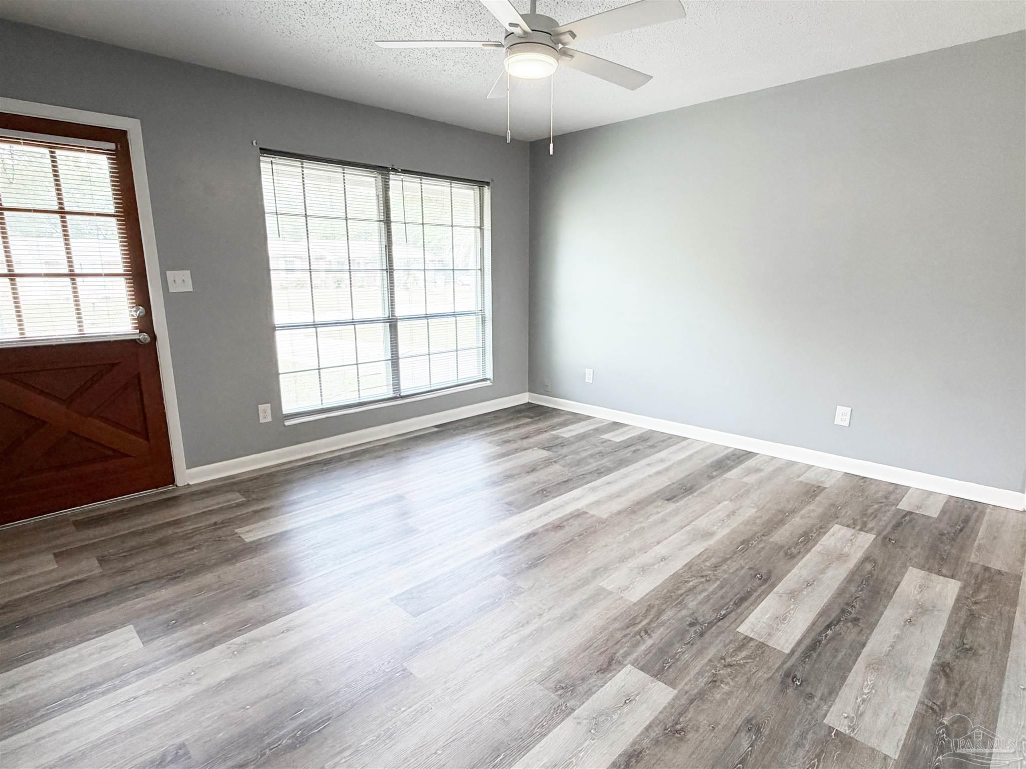 2053 Tomlinson Road Pensacola, FL 32526 - Photo 3 of 27 an empty room with wooden floor and windows