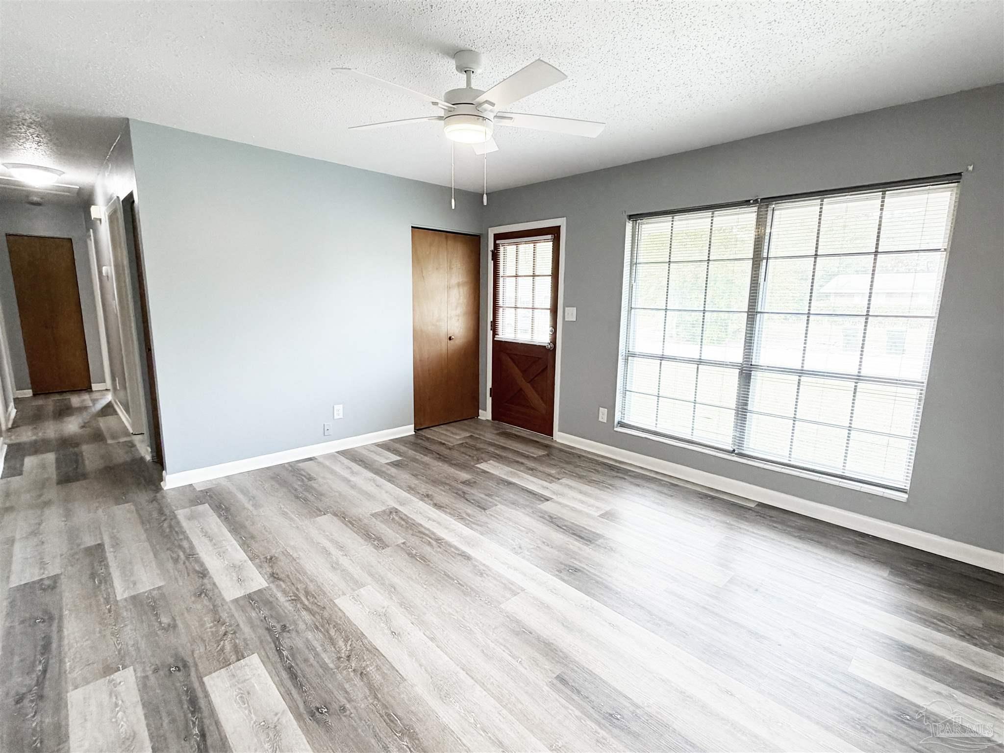 2053 Tomlinson Road Pensacola, FL 32526 - Photo 4 of 27 an empty room with wooden floor and windows